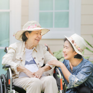 caregiver and old woman cheerfully talking